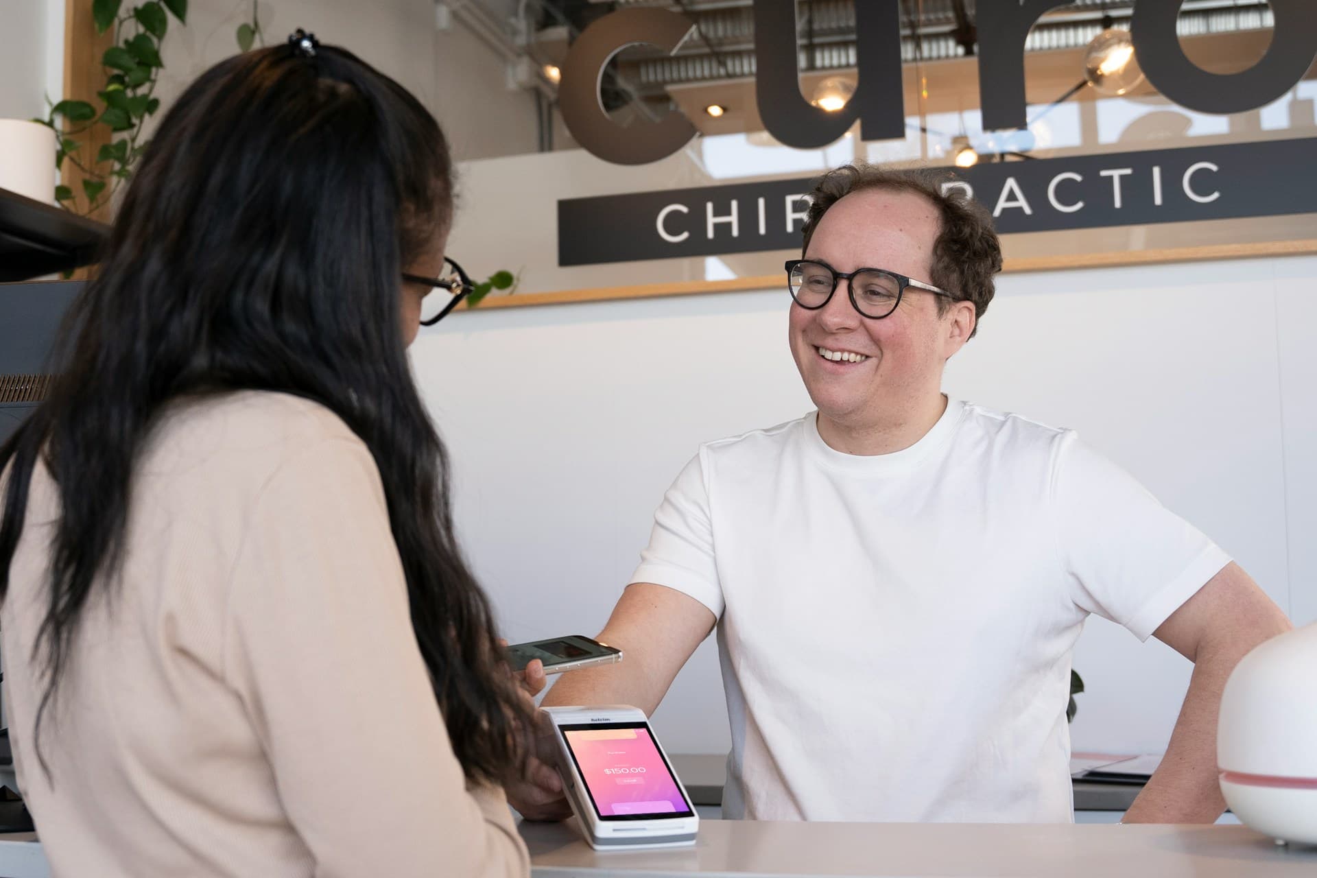 Patient checking in at the front desk of a chiropractic clinic