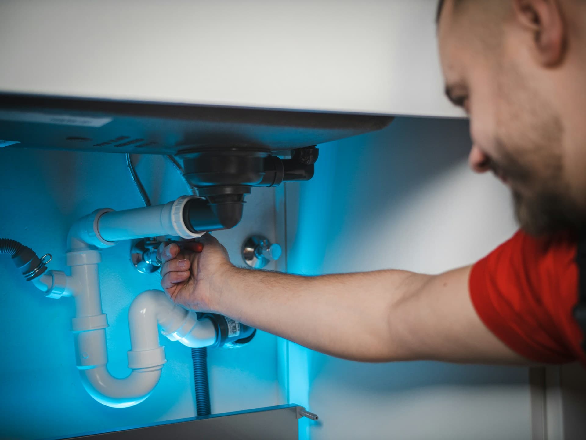 Plumber working under a sink